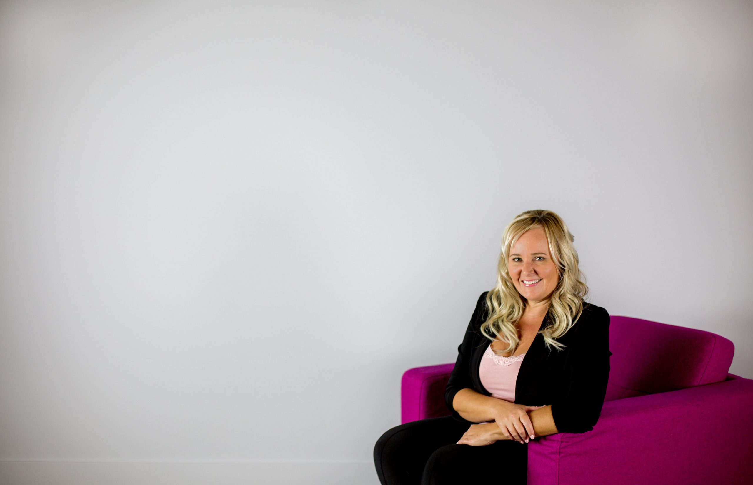 Kelly Caldwell seated on a pink couch — Guelph REALTOR®